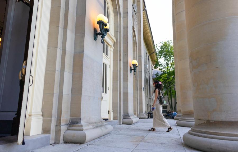 Student walking into Goldwin Smith Hall